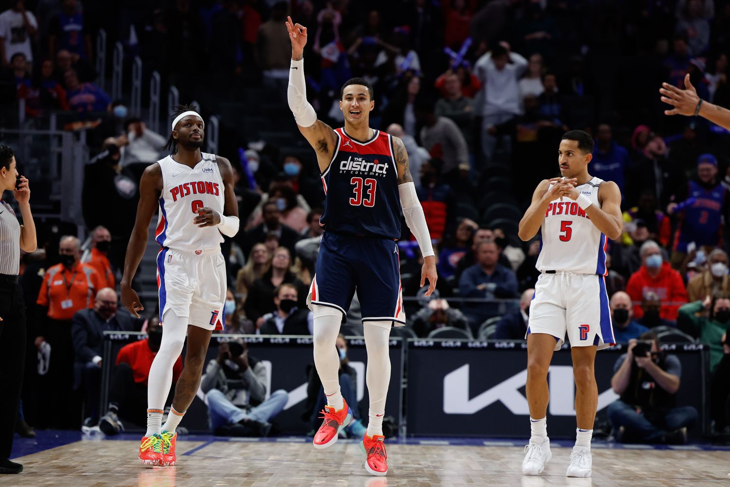 Washington Wizards forward Kyle Kuzma (33) celebrates his three point basket in overtime as Detroit Pistons forward Jerami Grant (9) reacts at Little Caesars Arena.